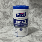 Studio product photograph of Purell Healthcare Surface Disinfecting Wipes canister on grey marble background
