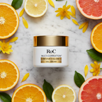 RoC Multi Correxion Revive + Glow Gel Cream on marble with citrus slices and yellow flower petals.