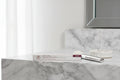 Arbonne Matte and Shine Lip Duo Bloom on marble makeup vanity with natural daylight lifestyle