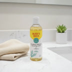 Burt's Bees Breakout Defense Foaming Wash on white quartz bathroom vanity with bamboo washcloth and small succulent