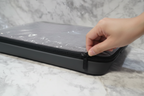Hand zipping Targus Strata grey heather protective laptop sleeve on neutral marble surface
