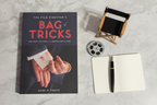 The Film Director's Bag of Tricks by Mark W. Travis flat lay with film reel director's chair pen and notebook on dark surface – More4less Outlet