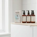 Gillette Venus Pubic Hair & Skin Razor Kit on minimalist bathroom cabinet shelf with luxury apothecary grooming bottles