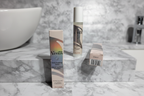 Gillette Venus Daily Soothing Serum slim pump bottle with white cap and holographic label alongside retail carton on white marble vanity in soft natural light