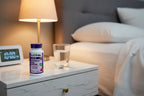 Natrol Melatonin 5mg on nightstand with water glass and alarm clock bedtime lifestyle