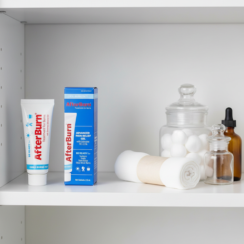 AfterBurn Lidocaine 2.5% Cooling Gel 2oz tube on minimalist white medicine cabinet shelf with rolled bandages and apothecary jars