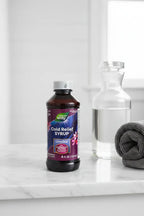 Nature's Way Umcka Syrup 4oz on white marble bathroom vanity with glass water carafe and rolled gray towel — More4less Outlet