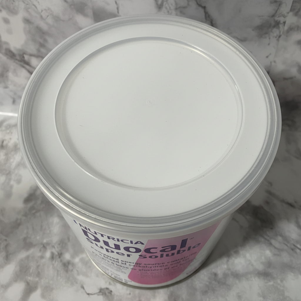 Close detail of the sealed lid and upper rim of a Nutricia Duocal 400 g can