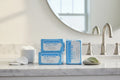 Clean white bathroom vanity with light blue Rodan + Fields Redefine Eye Cloths package
