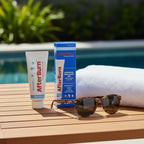 AfterBurn Lidocaine 2.5% Cooling Gel 2oz tube and box on teak patio table with sunglasses and white sun towel outdoors