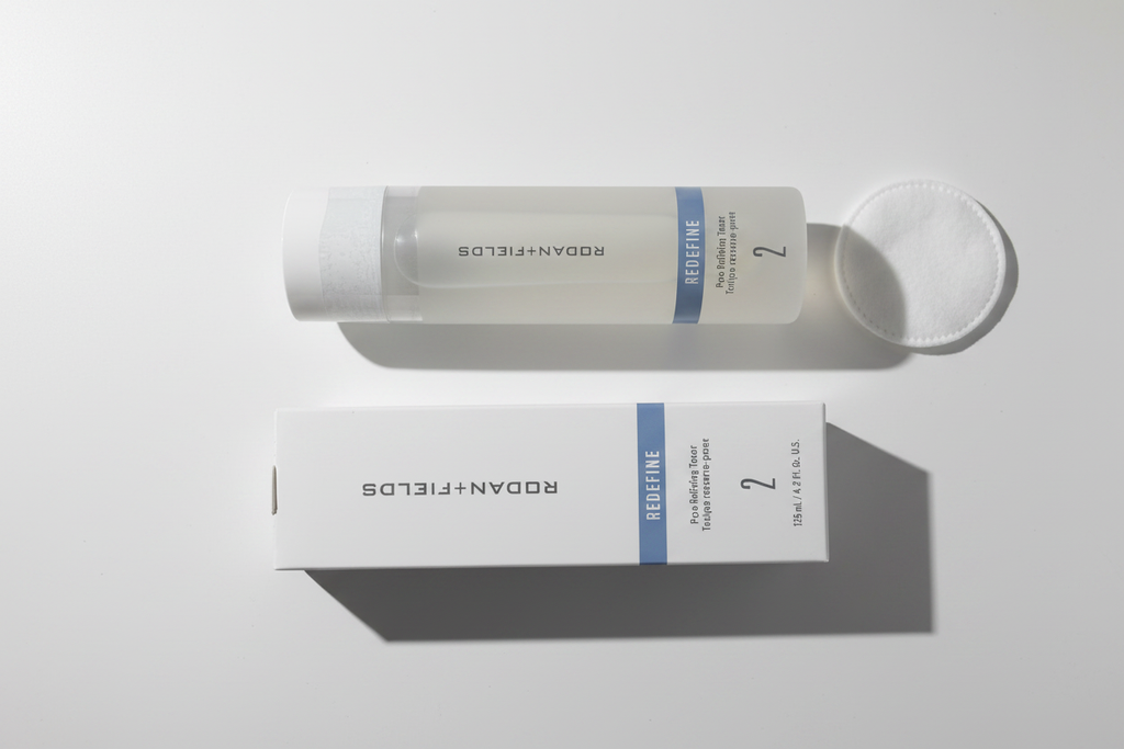 Rodan + Fields REDEFINE Pore Refining Toner bottle and box in minimalist morning routine flat lay with cotton pad