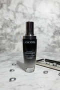 Luxury dark glass skincare serum bottle on a pristine white marble vanity with soft dramatic lighting
