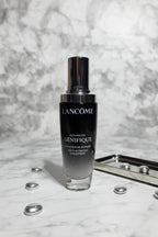 Luxury dark glass skincare serum bottle on a pristine white marble vanity with soft dramatic lighting