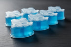 Macro-focused tabletop shot of clean blue replacement refill cartridges on dark stone background