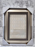 Malden picture frame with decorative border in packaging on a marble surface