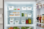 Modern stainless steel refrigerator interior organized with slim white storage containers and egg dispenser on clean shelf