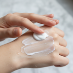 Close-up of luxurious white cream cleanser applied to smooth clean skin in soft natural light