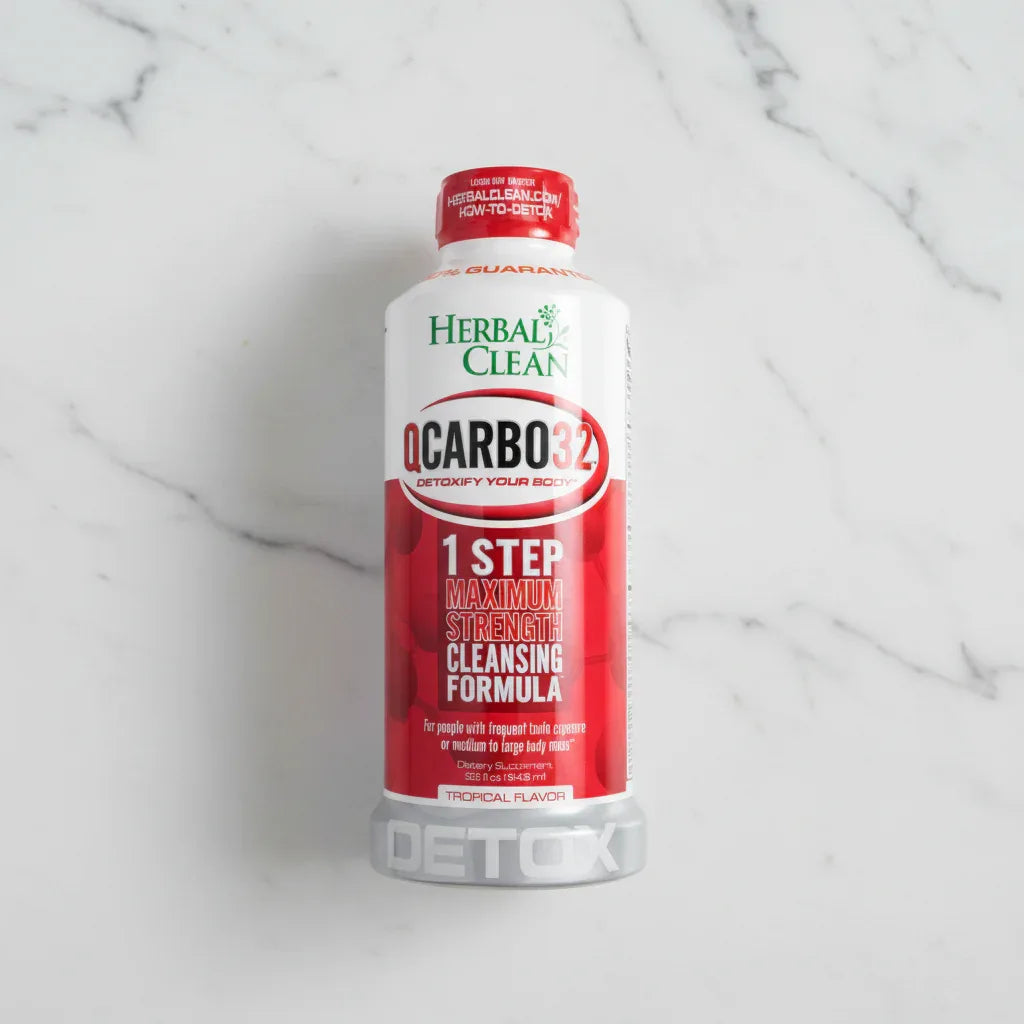 Overhead flat lay of Herbal Clean QCarbo32 health supplement drink bottle on white stone counter, clean neutral background