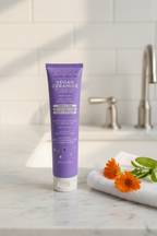 Pacifica Vegan Ceramide Face Wash on marble bathroom sink with calendula flowers and white towel