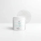 Clean minimal white bathroom counter featuring a white skincare jar with teal label accents