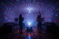 Bright rotating multicolor LED lights filling a dark living room creating a vibrant party atmosphere
