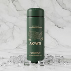 Matte dark green Akvati 32 oz water bottle on a white marble surface with ice cubes and water droplets, minimalist premium drinkware photography.