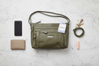 MultiSac Summerville olive green crossbody bag flat lay with phone keys wallet and essentials on marble — organized everyday carry purse