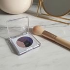 Mary Kay At Play Baked Eye Trio compact open on marble vanity with makeup brush and mirror