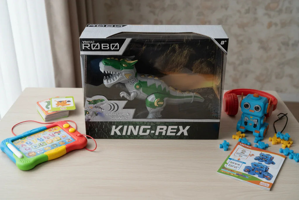 Vivitar Robo King-Rex motorized dinosaur toy on wooden desk near electronic accessories