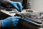 Technician replacing a dishwasher door microswitch in a bright professional workshop