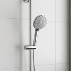 Grohe Euphoria 110 Duo polished chrome hand shower hanging on chrome slide bar in minimalist white tile bathroom with morning light