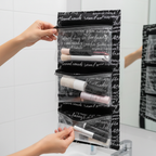 Person detaching clear zippered PVC pouch from velcro backing of unrolled hanging cosmetic organizer with script print