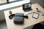 Solo New York Ludlow tablet sling on a desk next to a tablet and laptop — organized tech carry bag — More4less Outlet
