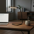 Globe Electric Arden LED Desk Lamp illuminated on modern dark-oak desk next to open laptop and ceramic mug