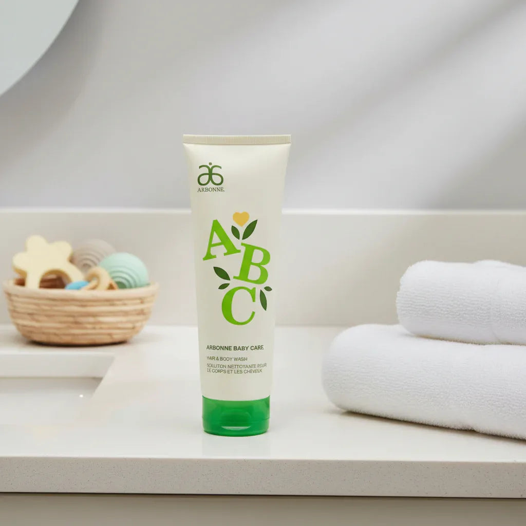 Arbonne Baby Care ABC Hair and Body Wash 8 oz on bathroom vanity with white towels and nursery elements