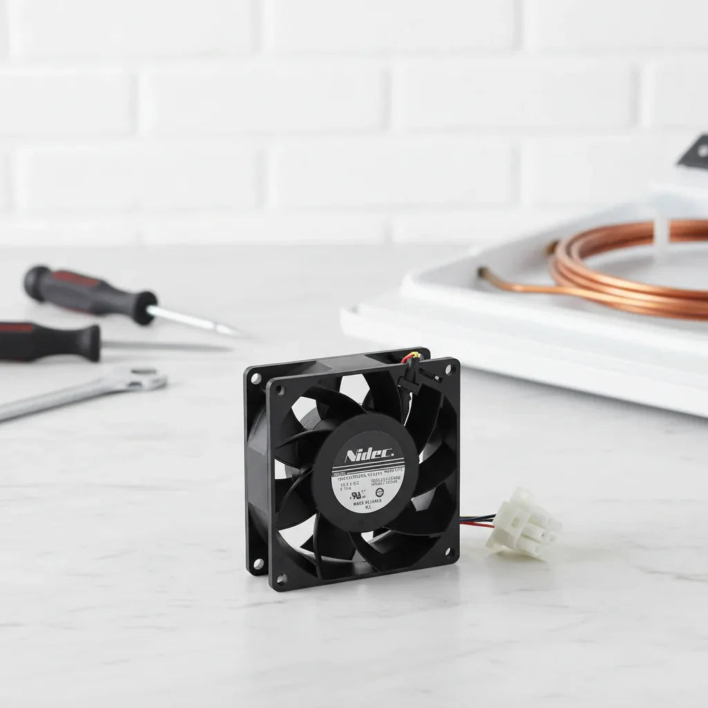Studio product layout of Nidec refrigerator fan motor replacement part on marble surface