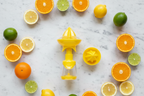 Core Kitchen citrus juicer and mister set flat lay with fresh lemons limes and oranges on marble — versatile kitchen tool for salads fish and vegetables