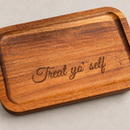 Angled detail of Treat Yo' Self engraving on acacia wood tray