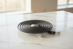 New black spiral coil electric range surface burner element on white marble with soft natural daylight