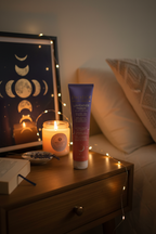 Pacifica Lavender Moon Body Lotion on nightstand with lavender candle moon phase art and fairy lights