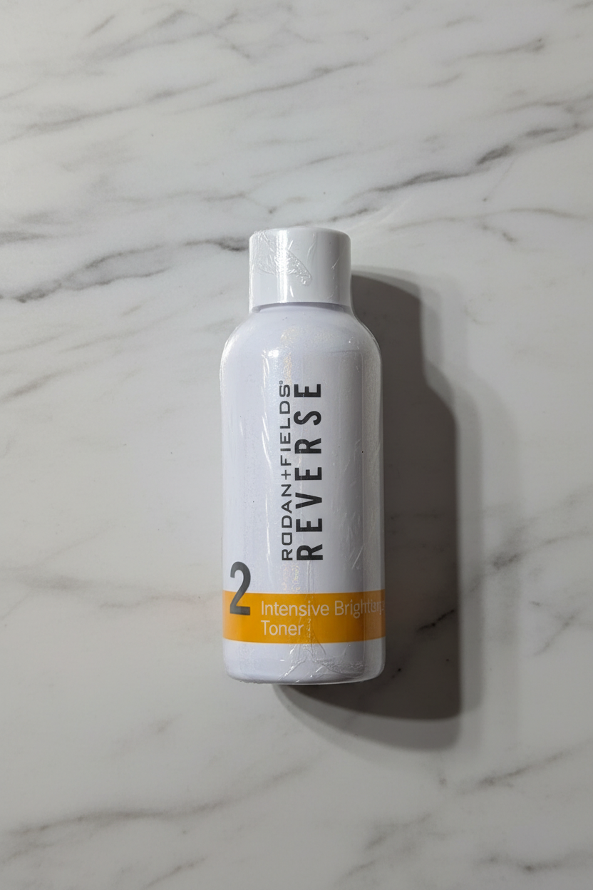 Rodan + Fields REVERSE Intensive Brightening Toner sealed white bottle on neutral marble background