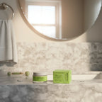 Bathroom vanity morning skincare routine scene with Cocokind moisturizer jar and green box beside a mirror, warm soft light
