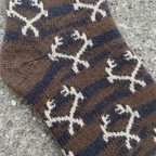 Close-up detail of navy brown merino wool blend sock texture with Realtree antler logo knit pattern on stone background