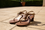 Lauren Ralph Lauren Westcott Polo Tan sandals displayed on a sunlit outdoor terrace with warm stone pavers
