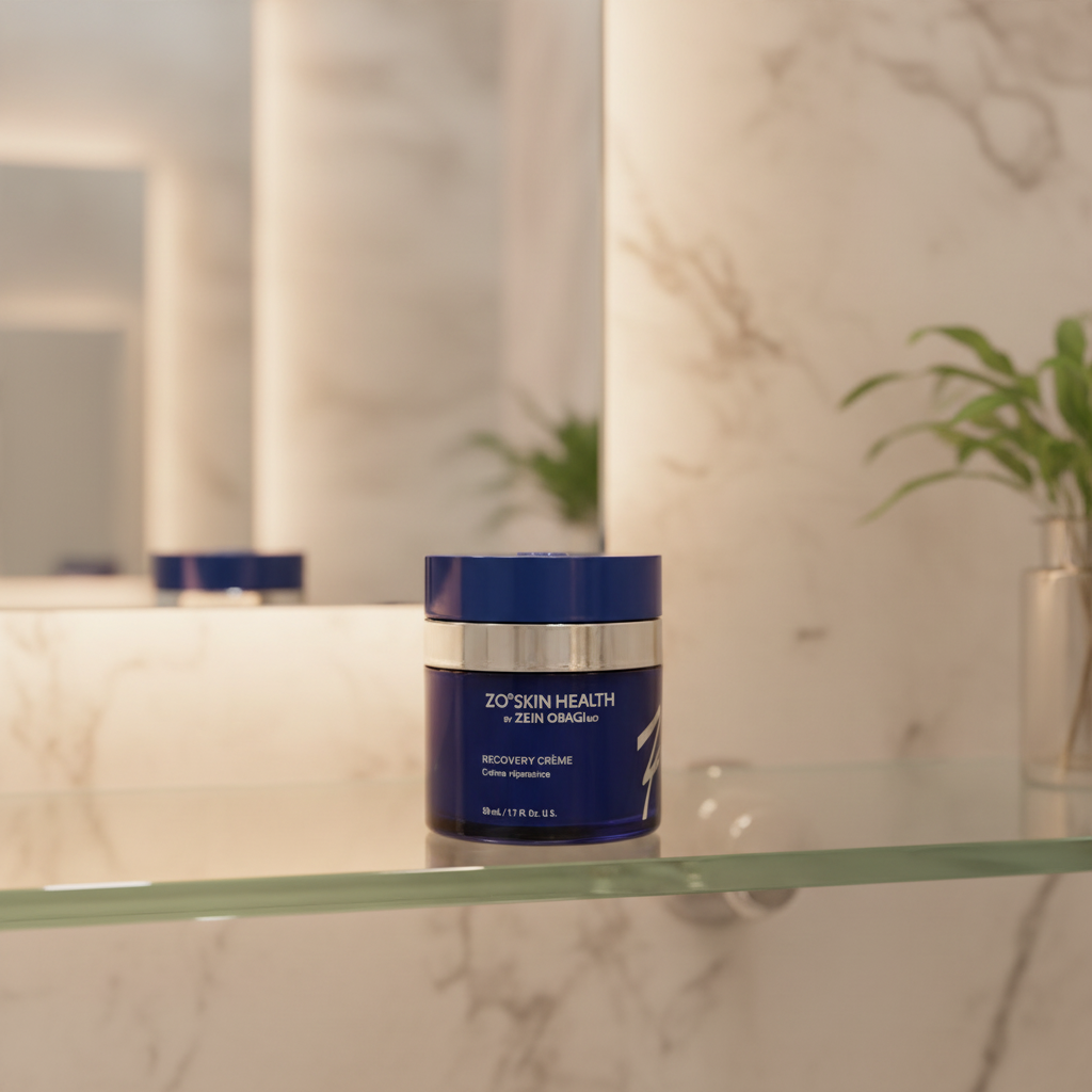 ZO Skin Health Recovery Crème navy blue jar on glass bathroom shelf with blurred spa background