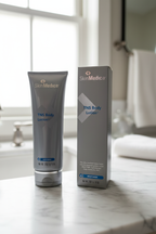 SkinMedica TNS Body Lotion tube and carton displayed on white marble bathroom vanity with soft natural light