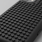 Extreme close-up macro of black silicone phone case back showing uniform grid of suction cups