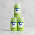 Three lime-green Ban Simply Clean bottles in pyramid on marble