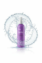 Water droplets splashing dynamically around a purple skincare facial mist spray bottle on a clean white background