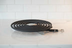 Professional close-up of a new black electric range coil burner element on a bright kitchen countertop